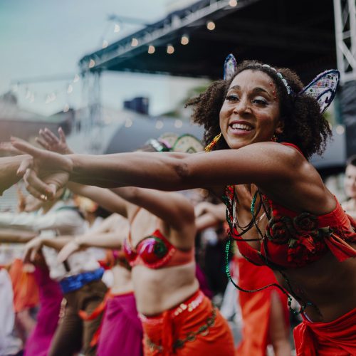 Smiling batucada dance crew dressed in red costumes