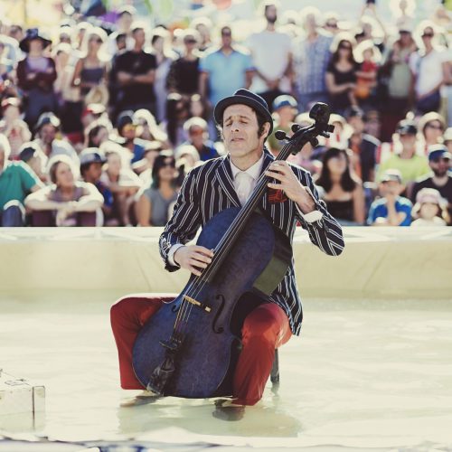 Man playing a cello in a water fountain