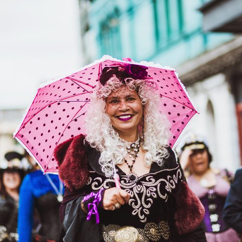 Female in costume with a pink polka dot umbrella