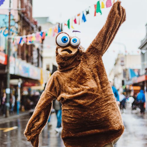 Person in Goo Goo Googly Eyes costume walking down the street
