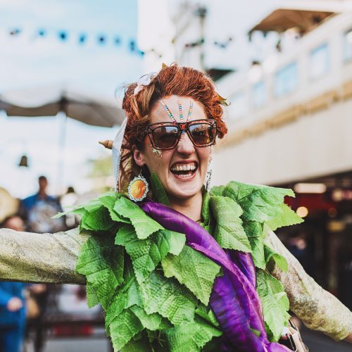 Smiling street theatre performer in leafy green costume