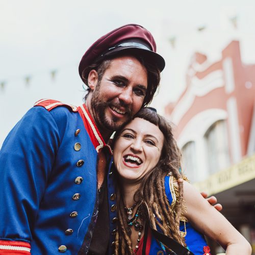 A man and a woman hugging and grinning at the camera