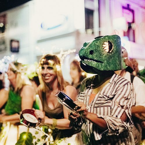 Batucada group performing in lizard costumes in the street