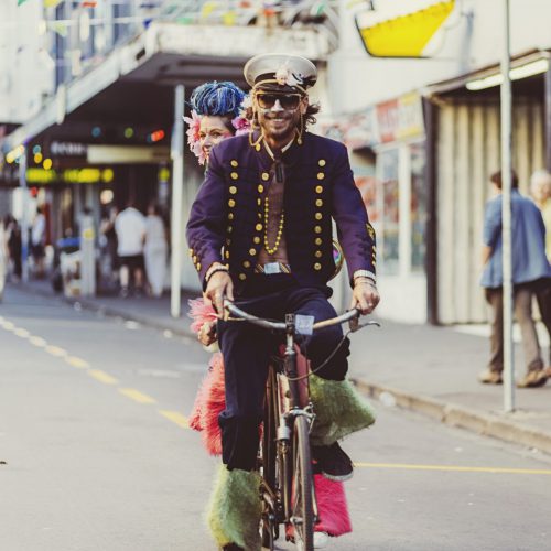 Two people riding a bike, dressed in costume