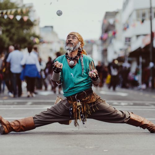 A shot of a man, doing some street theatre juggling, looks like he could be dressed as a pirate