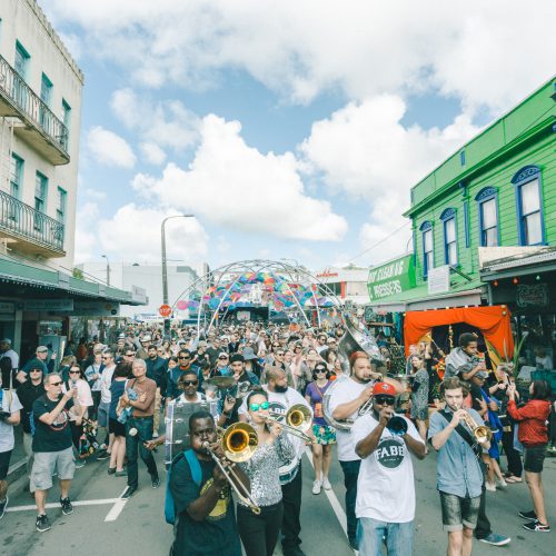 Big brass parage heading down upper Cuba Street from Laundry Bar underneath the big umbrella archway